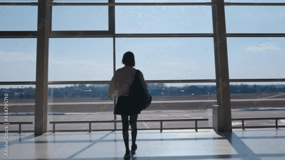 Back view of woman with backpack walking at airport Back view of woman with backpack walking at airport