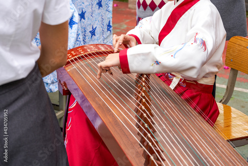 A little girl is playing the guzheng instrument photo