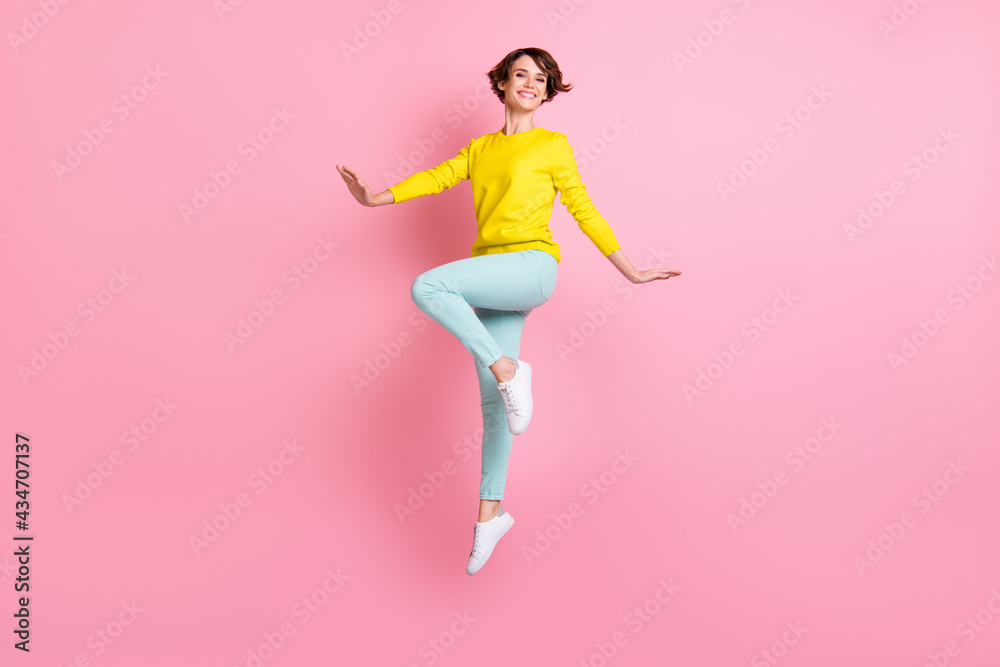 Full size photo of young pretty happy excited good mood girl with short wavy hair jumping isolated on pink color background