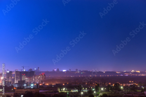 Night in city with lights, cityscape and dark night sky
