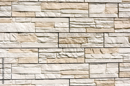 The wall is made of flat light brown stones. Background  sandstone wall texture.