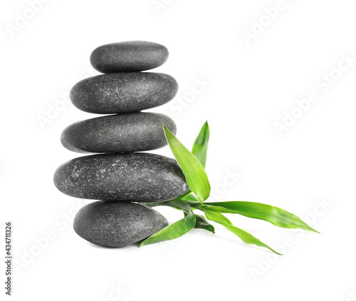Stack of spa stones and bamboo sprout on white background