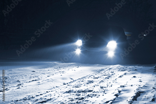 Car driving on a snowy country road in a snowstorm. © Nikamata