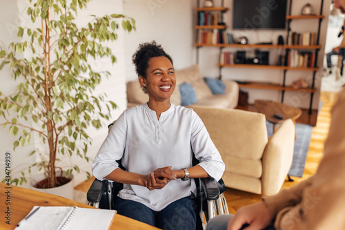 Happy disabled woman, talking to someone, at home office photo