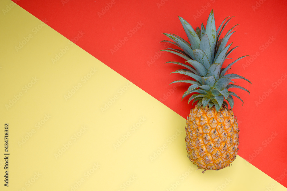 Victoria pineapple on the right side over a red and yellow background