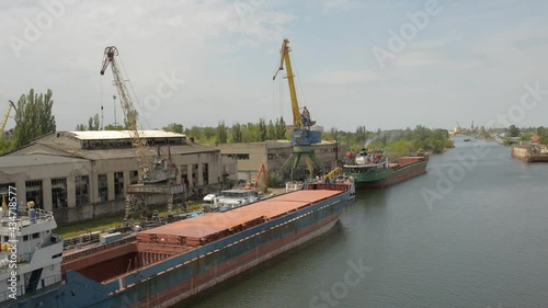 dry cargo ship with an open hatch moored in the port during the loading of scrap metal photo