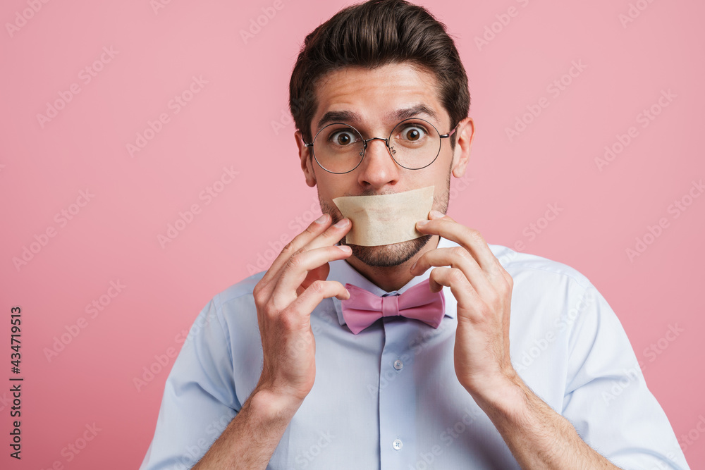 Young white man wearing bow tie frowning and looking aside Young white man wearing bow tie frowning and looking aside