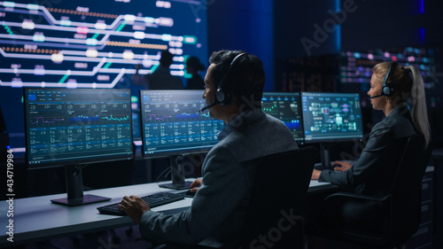 Team of Professional Traders Talking into Headsets Work on Computers with Screen Showing Finance Statistics, Charts Strategy, Stock, Telemarketing. Stock Firm Monitoring Room Stock Market Specialists