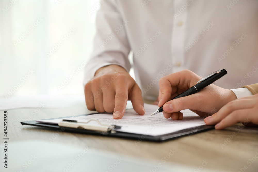 Businesspeople working with document at table indoors, closeup Businesspeople working with document at table indoors, closeup