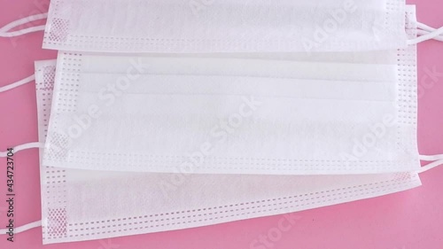 disposable masks, earloop type on soft pink surface, slowly movement