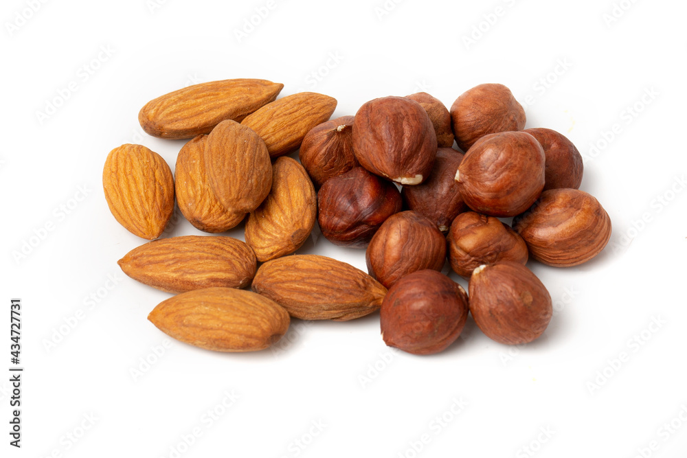 Close-up of hazelnut kernels and almonds on a white background. Close-up of hazelnut kernels and almonds on a white background.