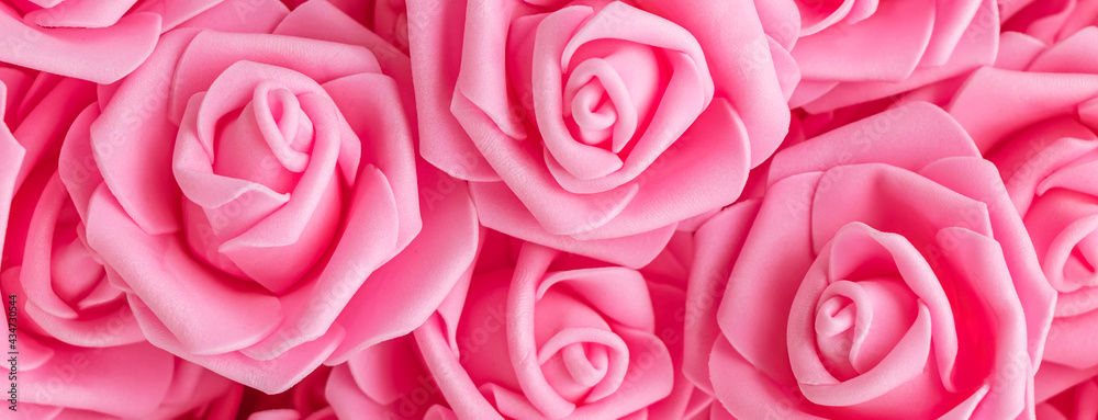 banner with background of fake pink roses. Top view. banner with background of fake pink roses. Top view.
