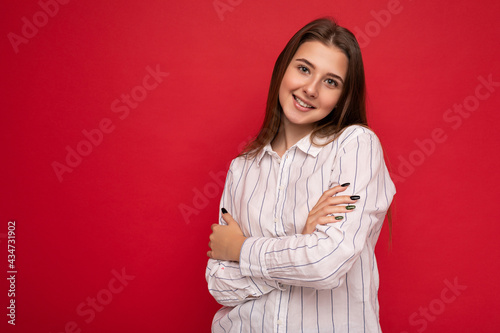 Photo of beautiful positive smiling adult woman wearing stylish clothes standing isolated on colorful background with copy space looking at camera