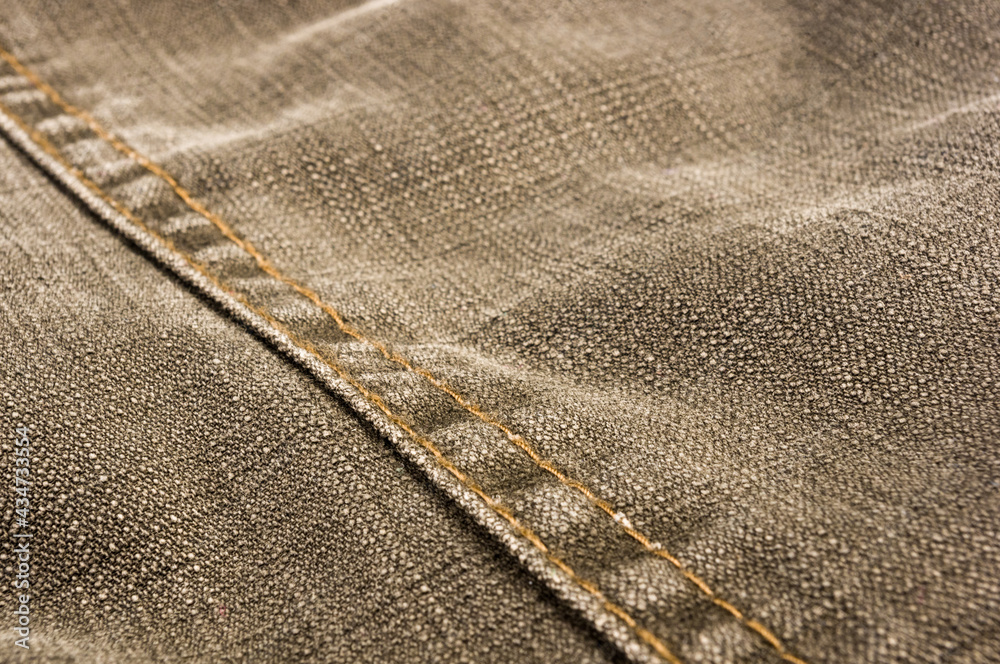 clothing items stonewashed cotton fabric texture with seams, clasps, buttons and rivets, macro