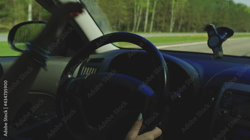 Video, woman hands drive a car, fingers lie on the steering wheel, beautiful fingers female hands