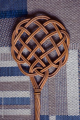close-up of a carpet beater lying on blue patterned carpet