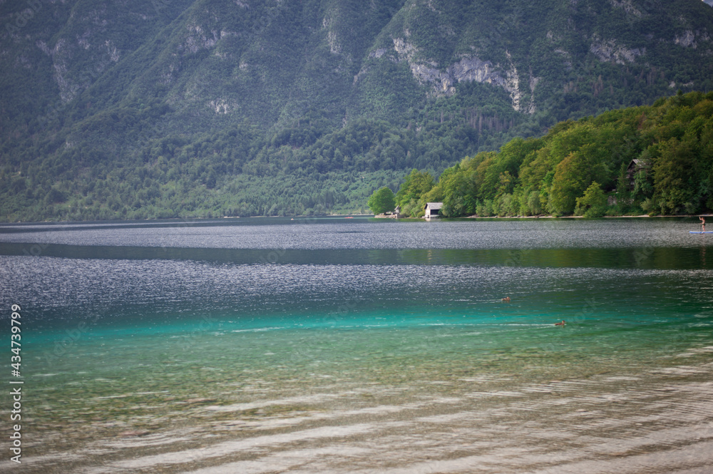 summer house on the shore of clear clean turquoise water of an alpine mountain lake