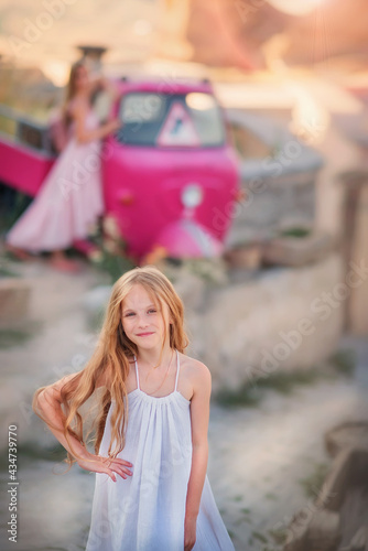 A girl with long hair stands in front of a pink retro car. Cappadocia. Turkey. Adventures © Taniya Larina