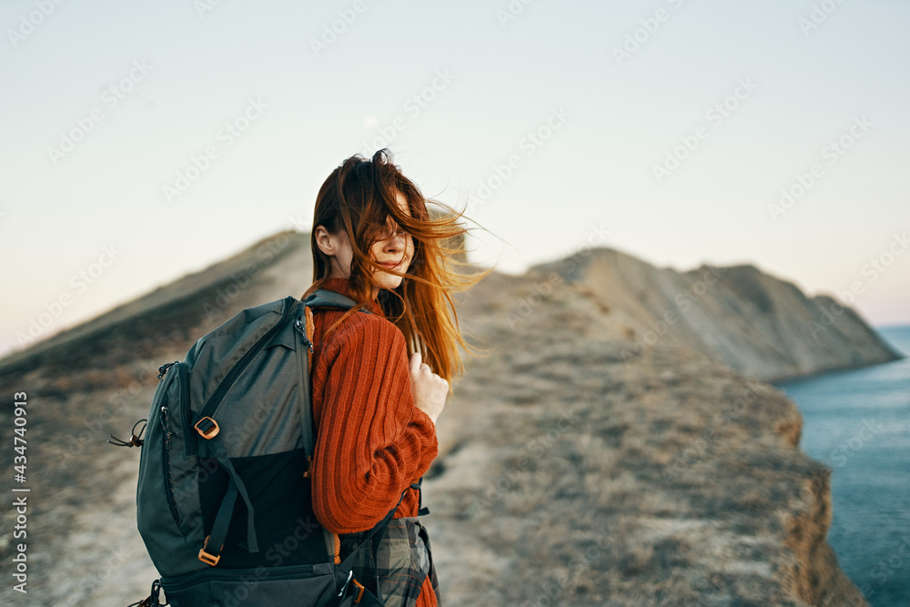 happy travel with backpack woman climbs to the top of the mountains along the path