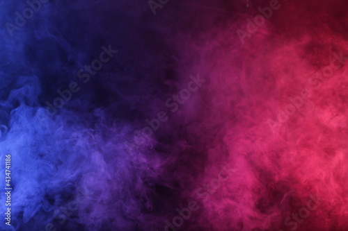 Artificial Smoke in red-blue light on black background
