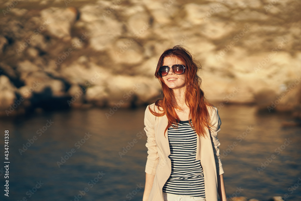 woman travels in the mountains adventure tourism model near the river in summer glasses woman travels in the mountains adventure tourism model near the river in summer glasses