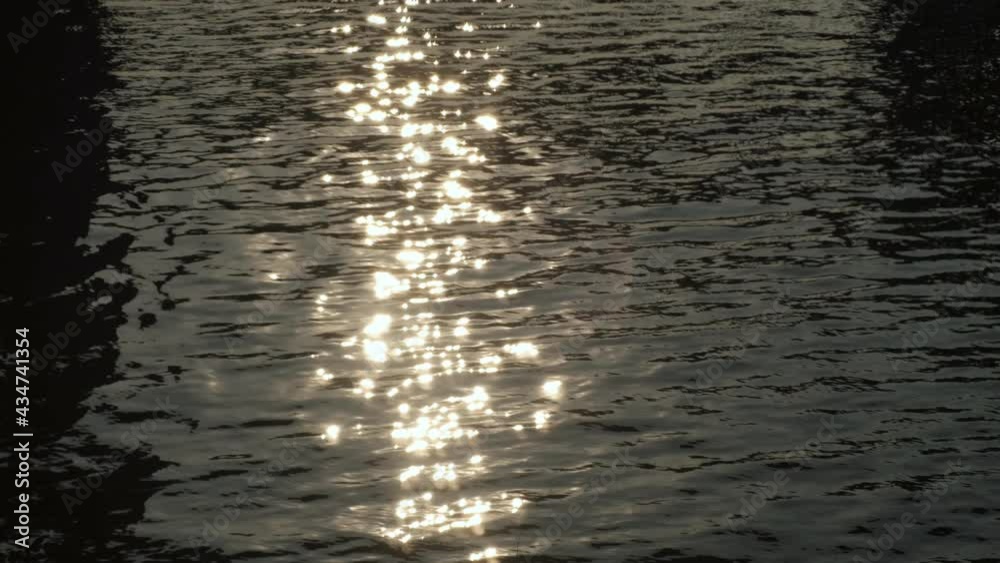 Defocused abstract blurred beautiful dramatic scenic bright vibrant wave ripples with warm sun light at sunrise morning on water surface of lake or river. Defocused abstract blurred beautiful dramatic scenic bright vibrant wave ripples with warm sun light at sunrise morning on water surface of lake or river.