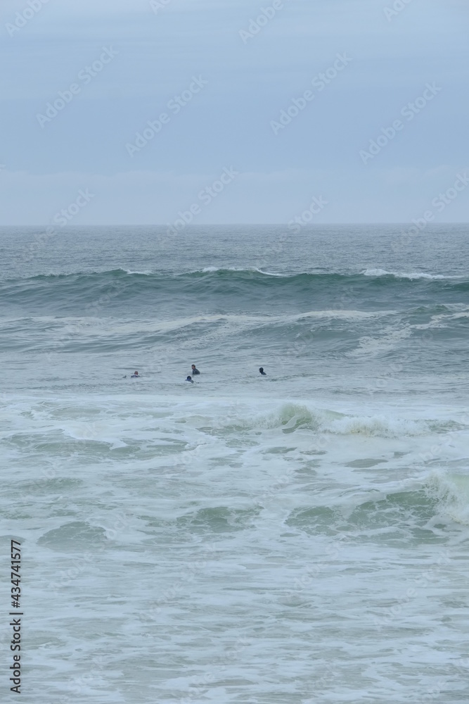 Some surfers enjoying big waves at la Govelle surf spot on the french Atlantic shore. France, city: Batz-sur-mer, the 9th may 2021.