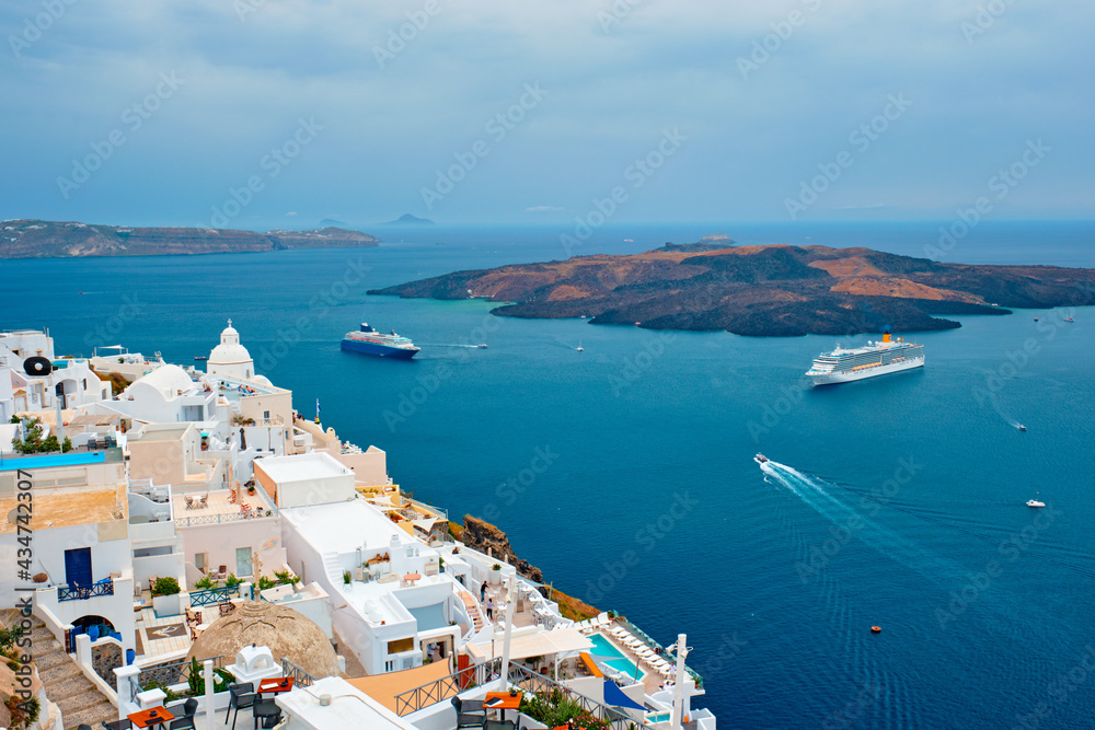View of Fira town on Santorini island with cruise ships in sea