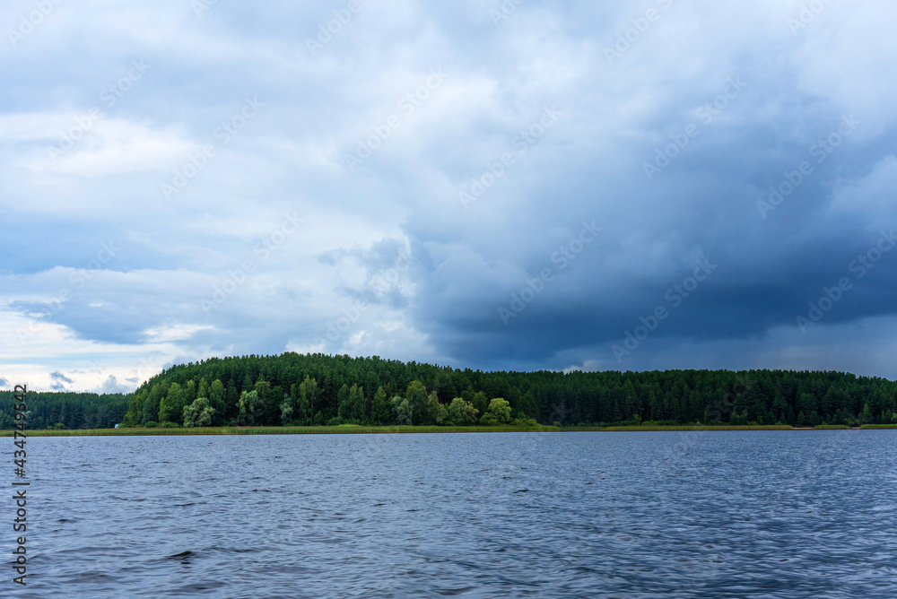 Panoramic summer view of Lake Seliger before a thunderstorm. Forest lake under a stormy sky. Panoramic summer view of Lake Seliger before a thunderstorm. Forest lake under a stormy sky.
