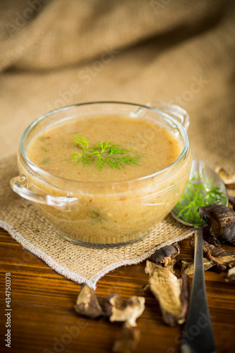 hot homemade vegetable vegetarian soup with dried mushrooms in a glass bowl