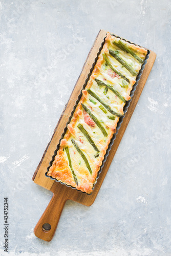 Step by step  recipe preparation of an asparagus and speck tart made with egg yolk, cream , parmisan , brisee pasta, speck and asparagus. prepared cooked and served, top view, flatlay composition photo