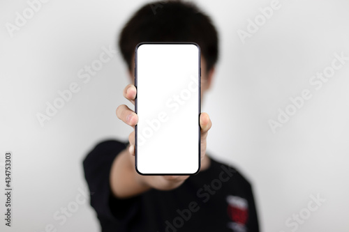 A man standing with a phone showing up in front of you, with room for your copy.