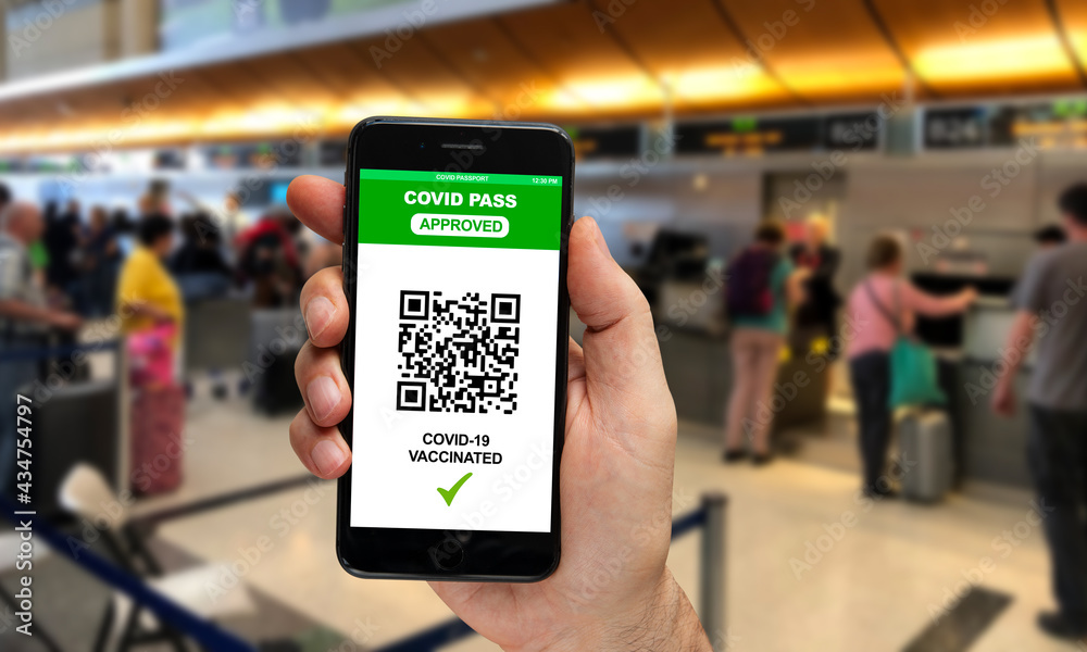 Hand holding smartphone display on app mobile vaccinated covid-19 or coronavirus certificate, immunity vaccine passport, at airport check in desk
