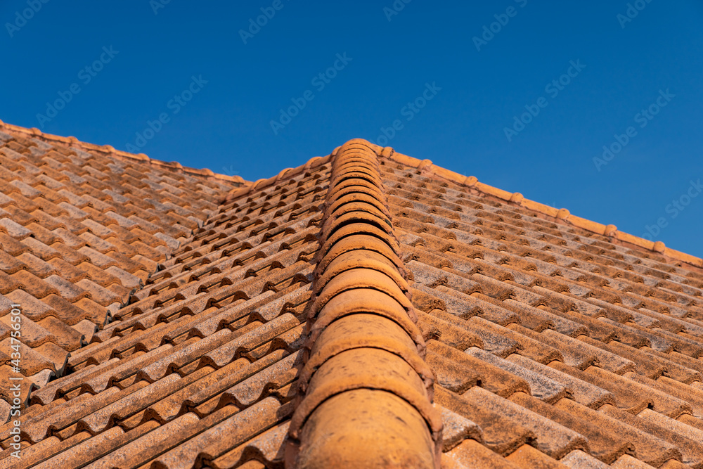 Naklejka premium Close up of brown clay roof tiles. Red old dirty roof. Old roof tiles. Construction equipment build a house.