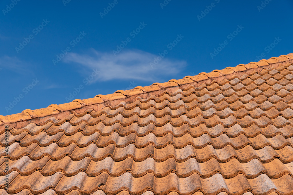 Close up of brown clay roof tiles. Red old dirty roof. Old roof tiles. Construction equipment build a house.