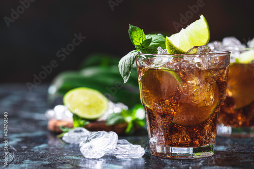 Cuba Libre with brown rum, cola, mint and lime. Cold Longdrink, alcohol cocktail. photo