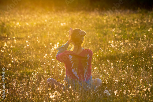 Woman meditating in a field during sunset hour