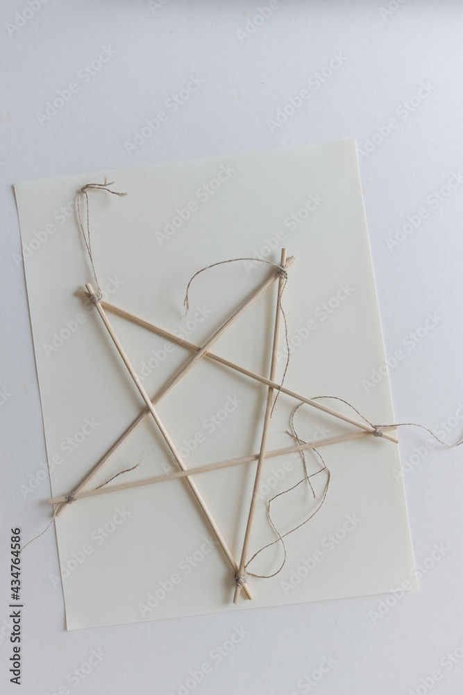isolated bamboo skewer 5 pointed arts and crafts star tied with twine on paper isolated bamboo skewer 5 pointed arts and crafts star tied with twine on paper