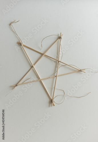 isolated bamboo skewer 5 pointed arts and crafts star tied with twine on paper