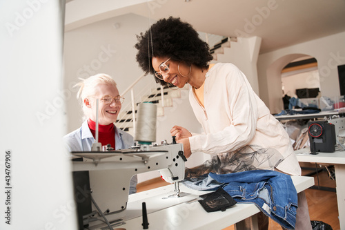 Woman critically looking at the sewing machine and smiling