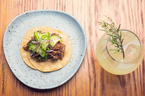 Gourmet tacos and cocktail with rosemary on wooden table. Gourmet mexican food