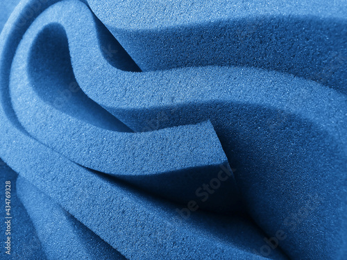 rolled up blue foam sponge. foam sponge rubber texture sheet. folds of irregular material photo