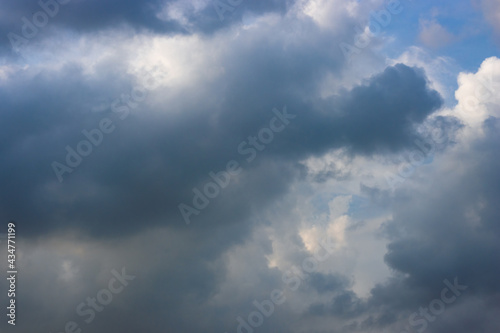 Dark blue cloud moving under the blue sunny sky