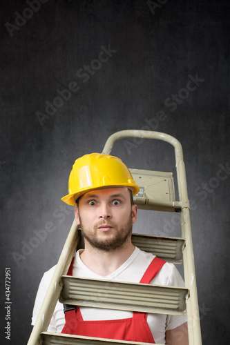 Obraz na plátne Portrait of a clumsy worker with ladder