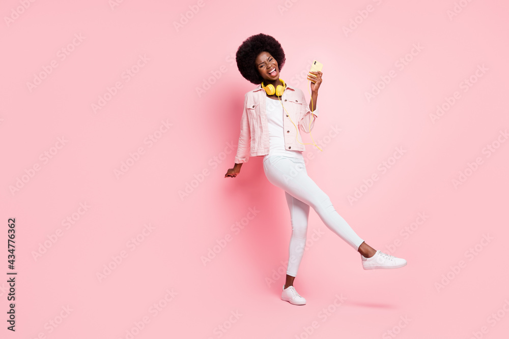 Full length body size view of lovely ecstatic cheerful girl listening pop hit dancing having fun isolated over pink color background Full length body size view of lovely ecstatic cheerful girl listening pop hit dancing having fun isolated over pink color background