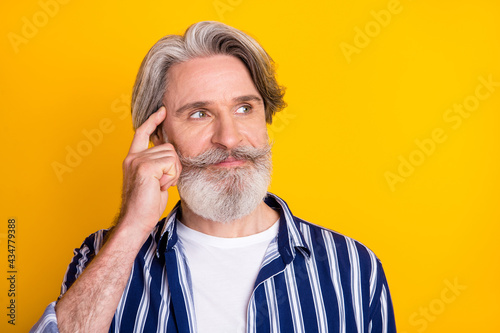 Photo of happy good mood handsome mature man look copypsace thinking isolated on yellow color background photo