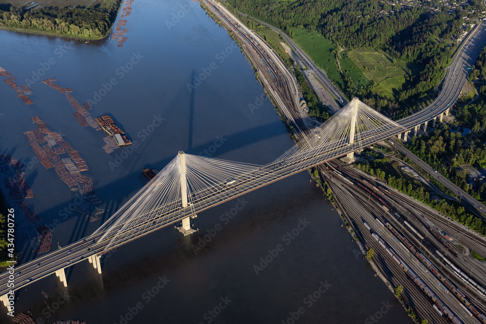 Obraz premium Aerial view on Fraser River and Port Mann Bridge. Taken from Airplane in Greater Vancouver, British Columbia, Canada. Sunny blue sky evening.