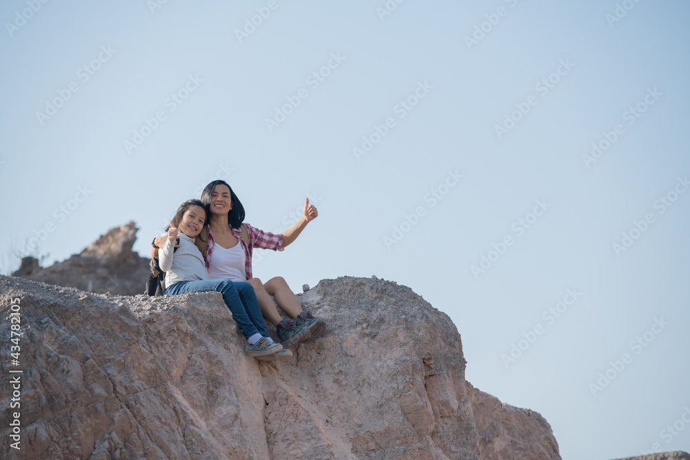 family travel- hikers with backpack looking at mountains view, mother with child at the day time, little girl with mother trekking on red trail, Concept of friendly family. family travel- hikers with backpack looking at mountains view, mother with child at the day time, little girl with mother trekking on red trail, Concept of friendly family.