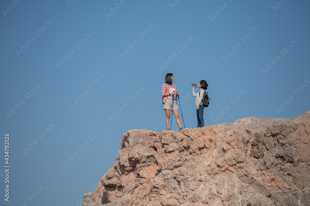 family travel- hikers with backpack looking at mountains view, mother with child, little girl with mother trekking on red trail, drinking water, Concept of friendly family.