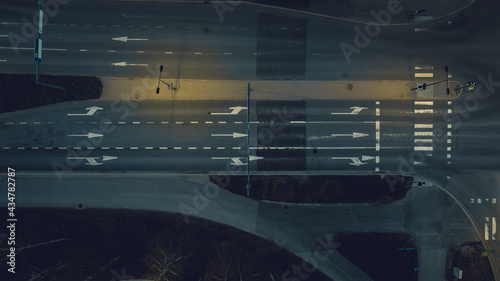 Aerial view of a junction with road markings at night.